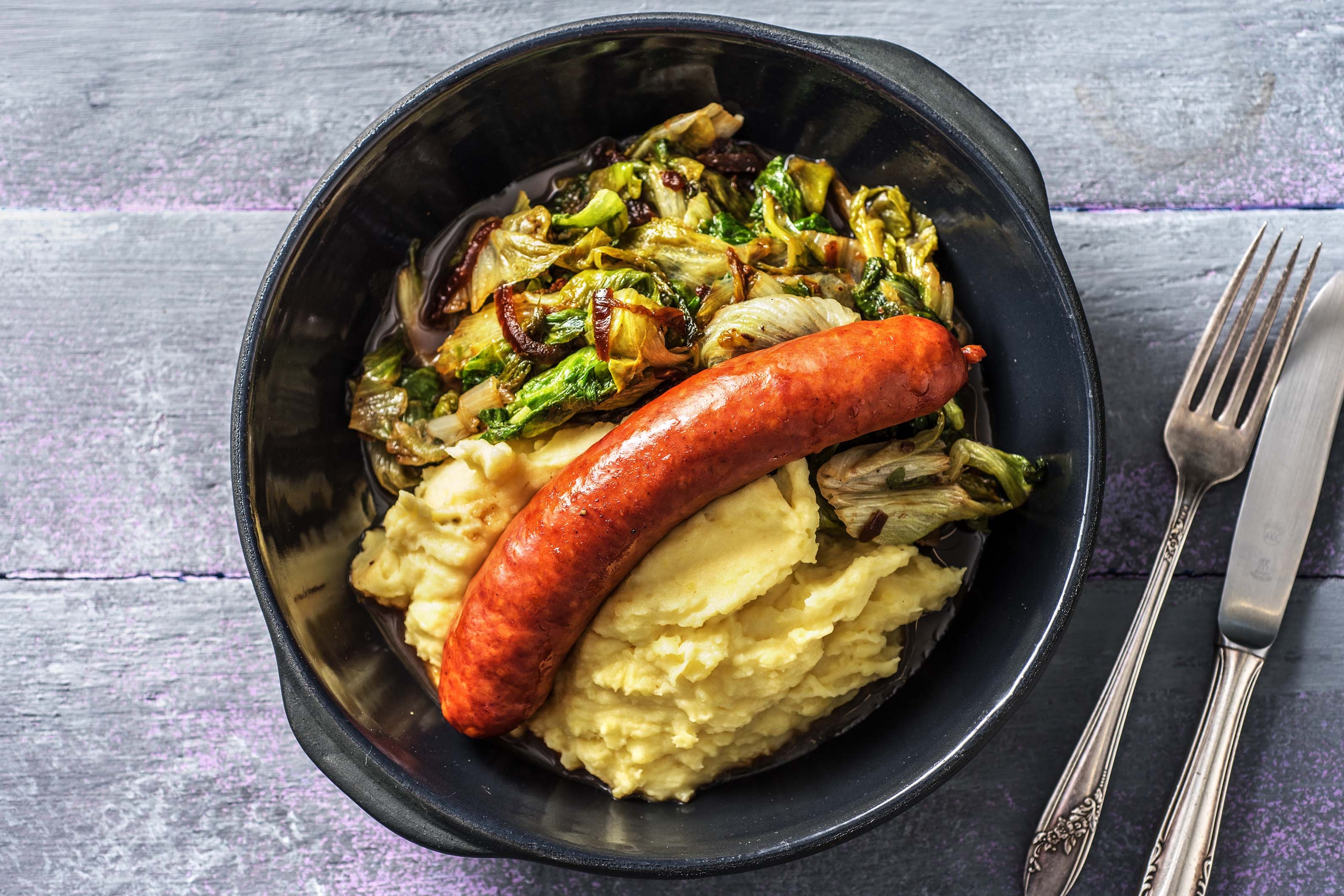 Saucisse fumée et chicorée frisée poêlée