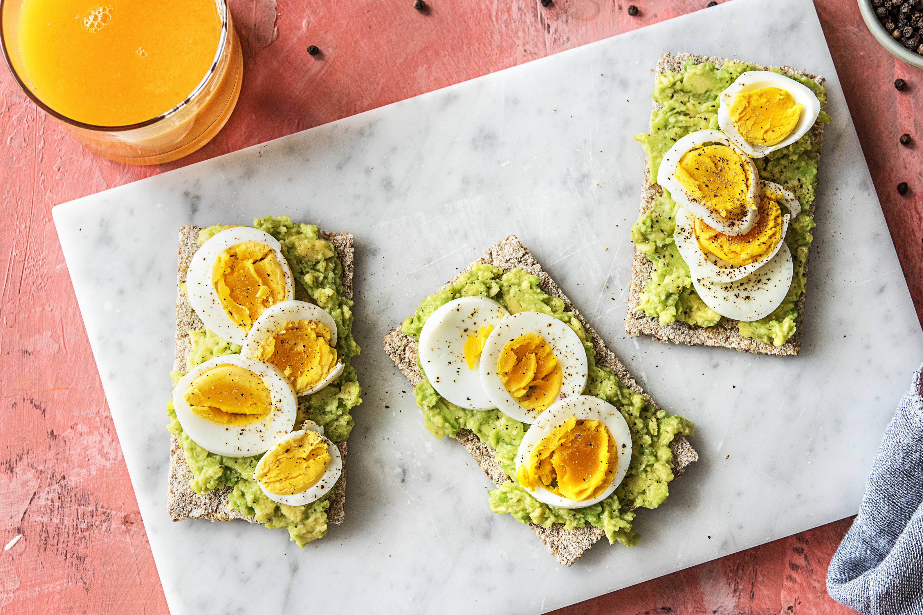 Vezelrijke cracker met avocado, gekookt ei en verse jus d’orange