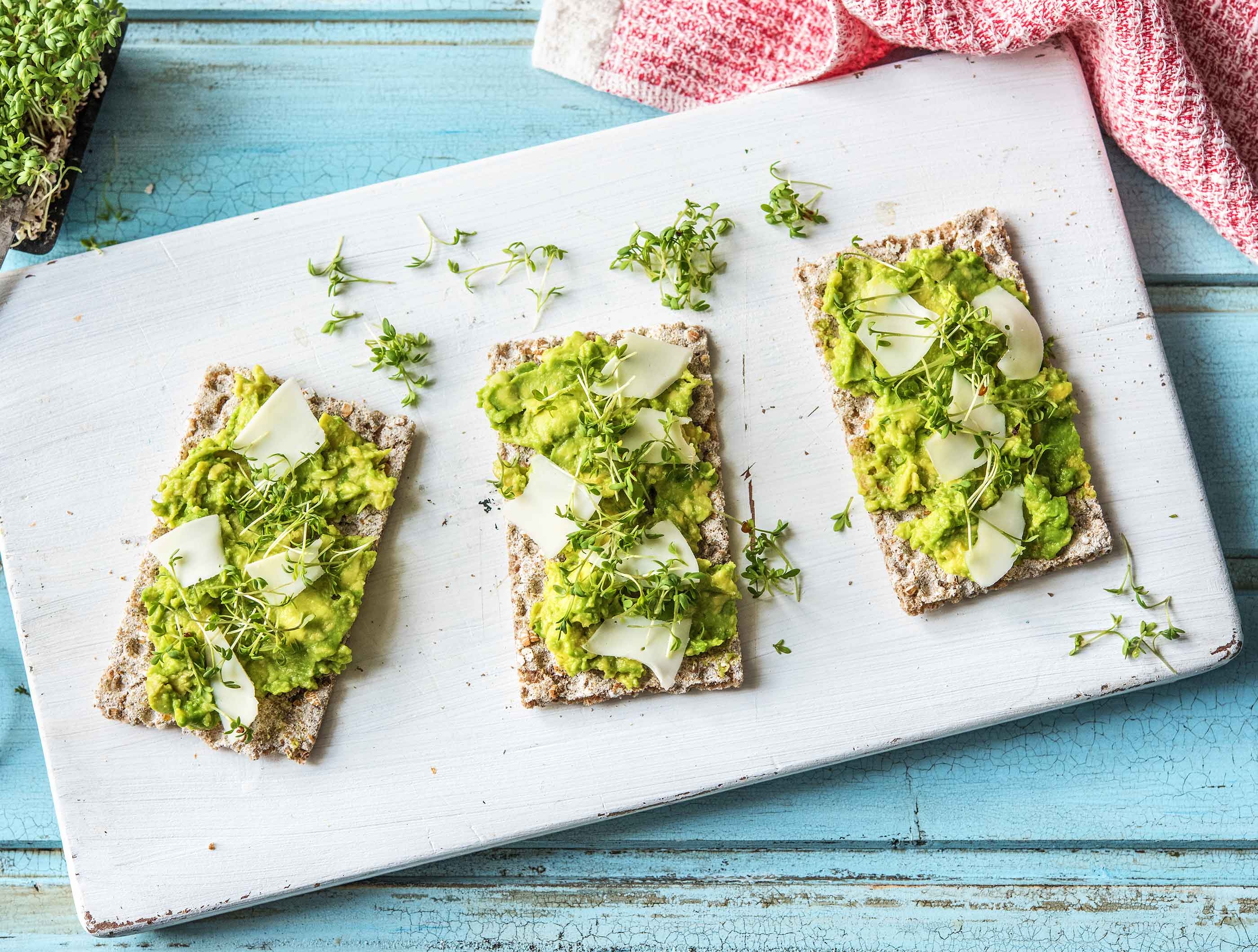 Vezelrijke crackers met avocado, geitenkaasvlokken en tuinkers
