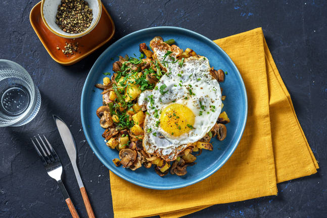 Gebakken patatjes met spiegelei en champignons
