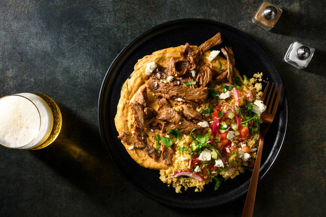 Bowl met biefstukreepjes, feta en puntpaprikahummus