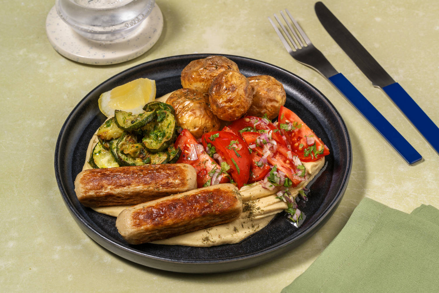 Mezzeschotel met kipworstjes en zhoug-courgette