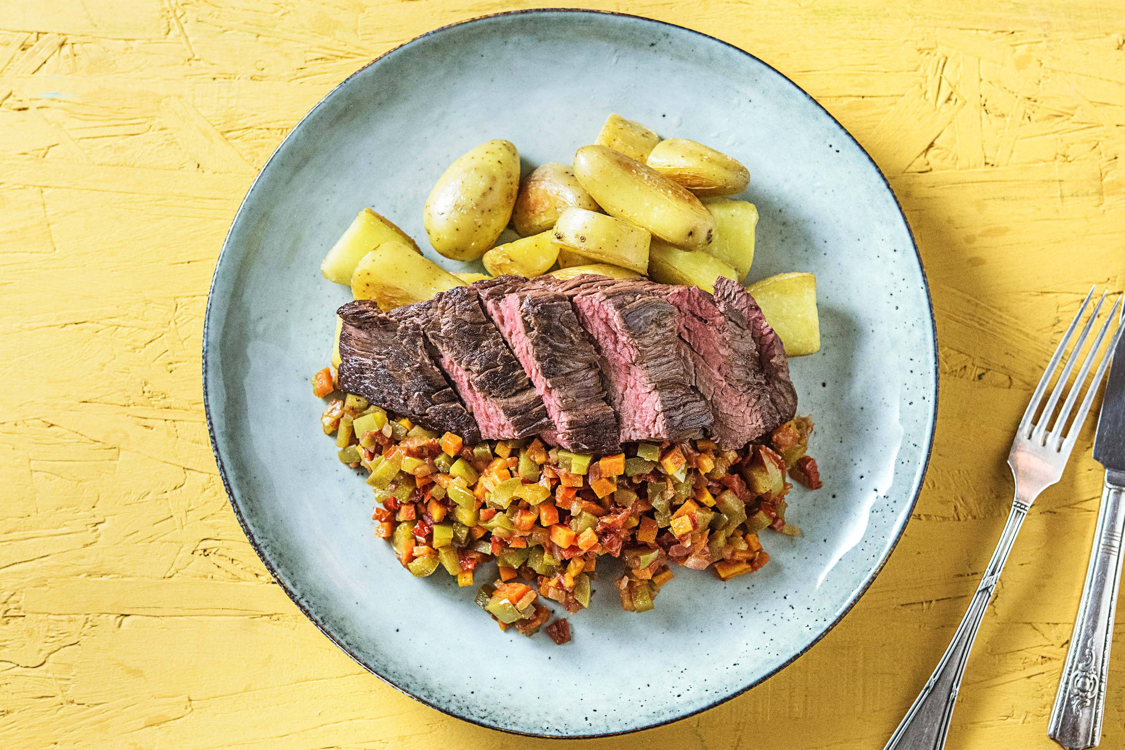 Bavette met krieltjes en een groentestoof van rode ui, peen en groene paprika