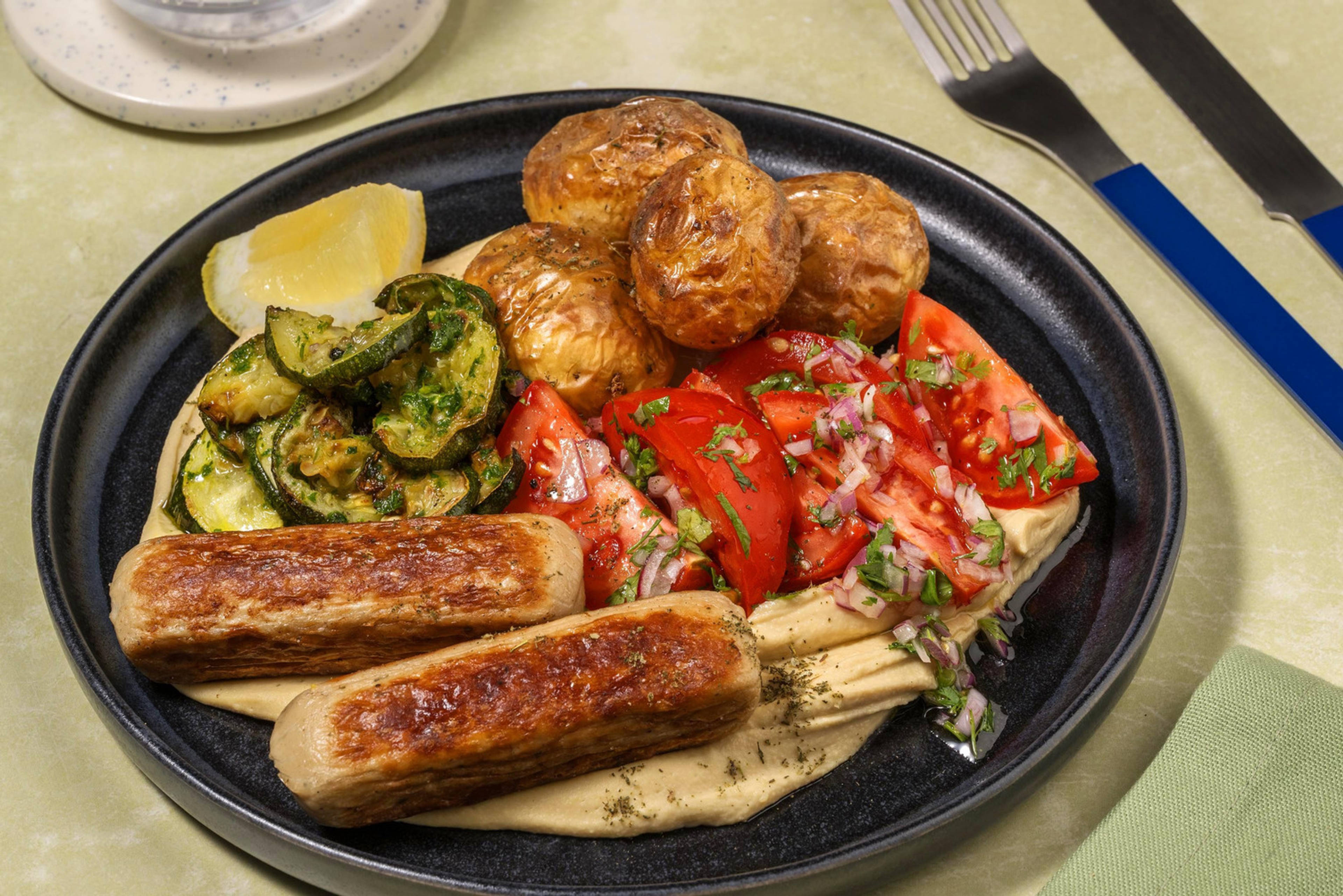Mezzeschotel met kipworstjes en zhoug-courgette
