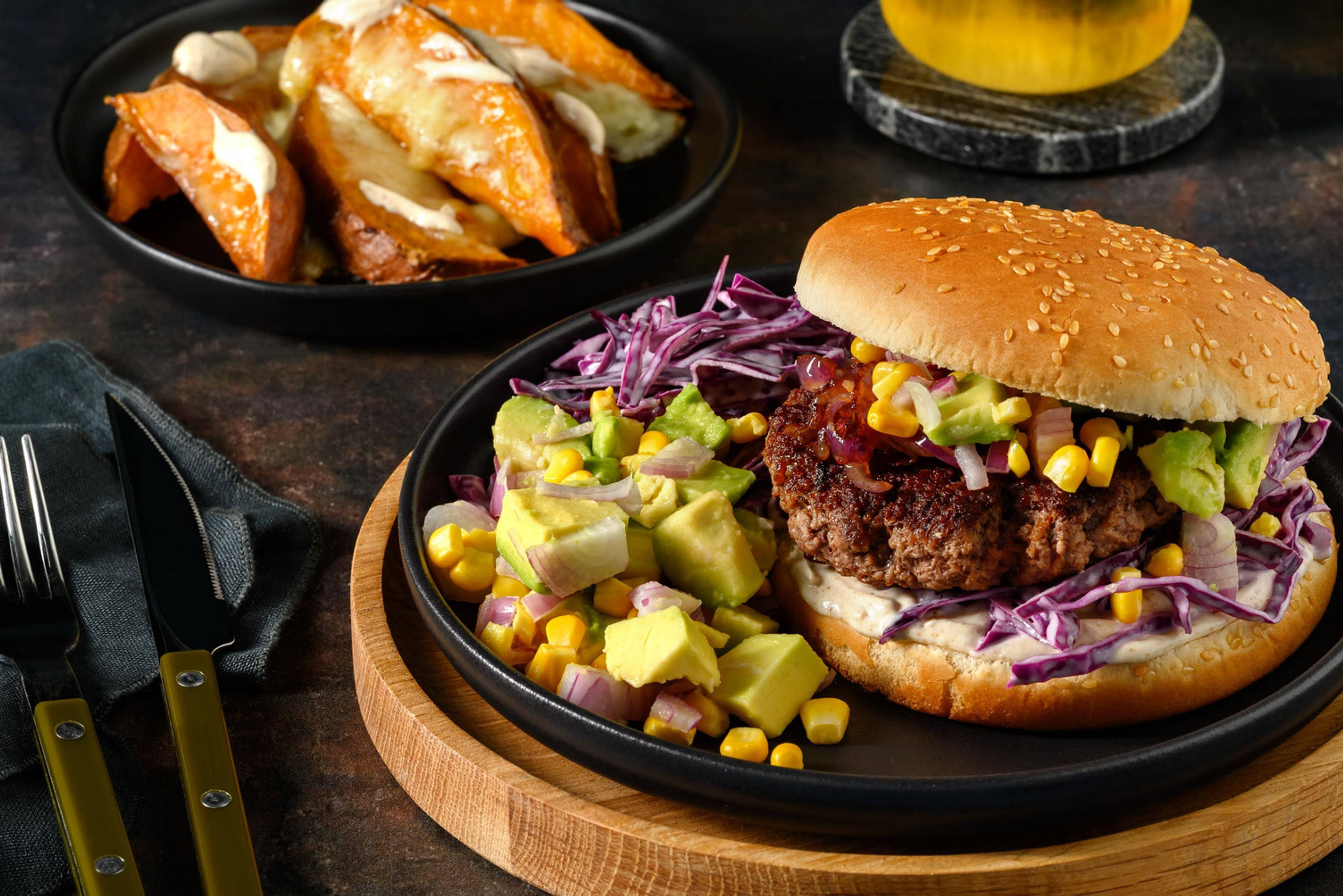 Kalfsburger deluxe met kruidige avocadosalsa en cheesy zoete-aardappelpartjes