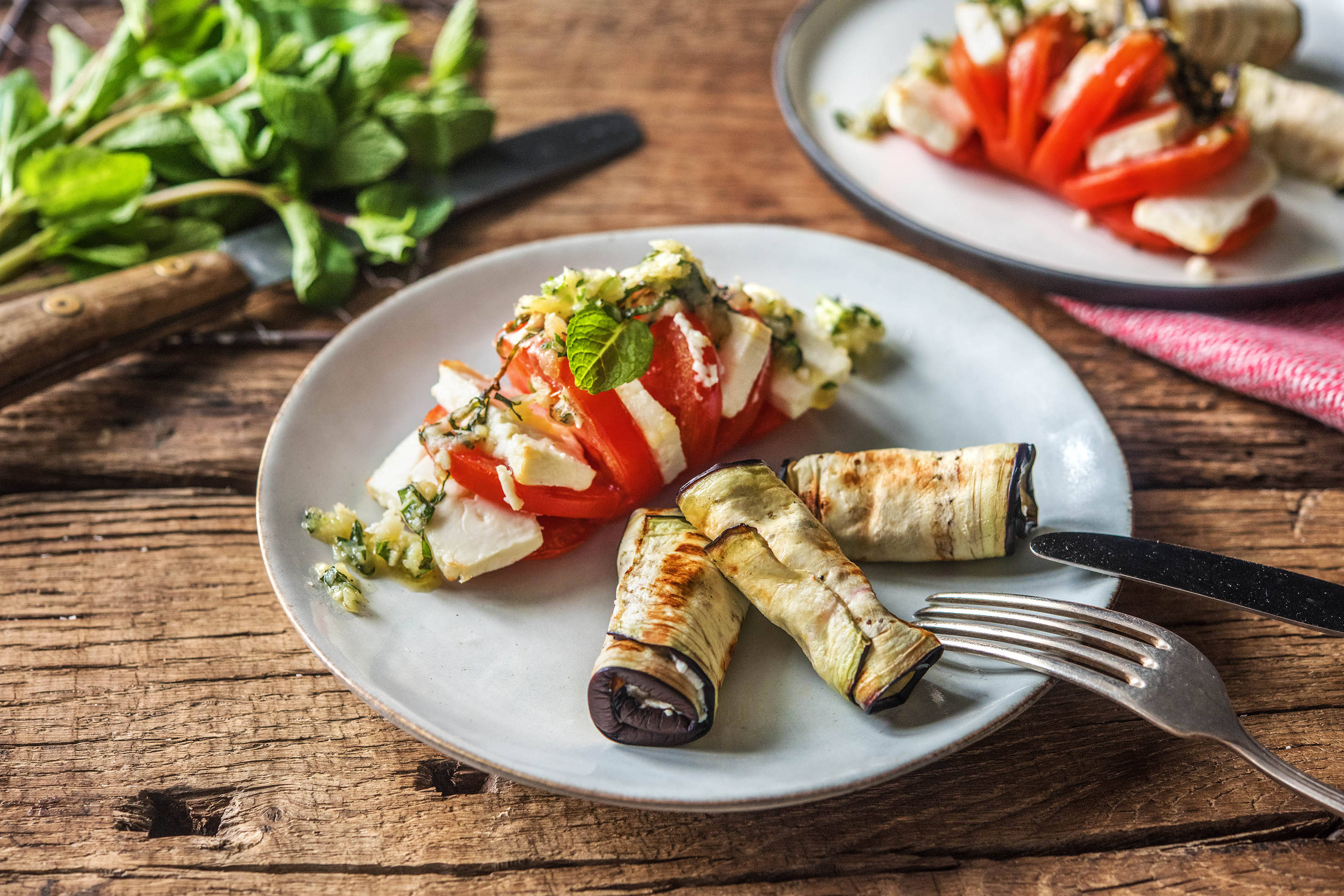 Würzige Auberginenröllchen mit Hasselback-Tomaten