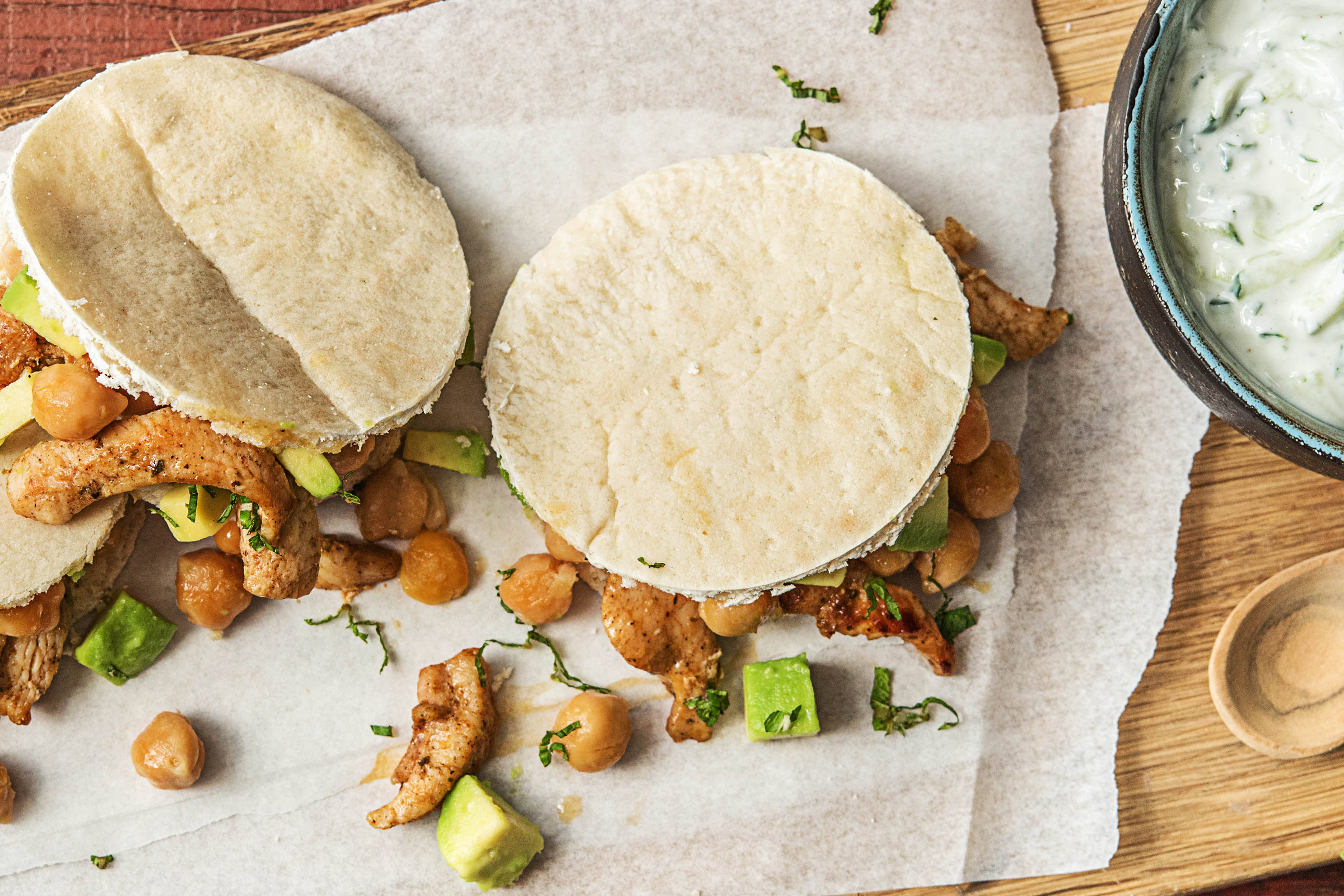 Kipgyros met avocado-kikkererwtensalade, komkommer-knoflooksaus en knapperige pitabroodjes
