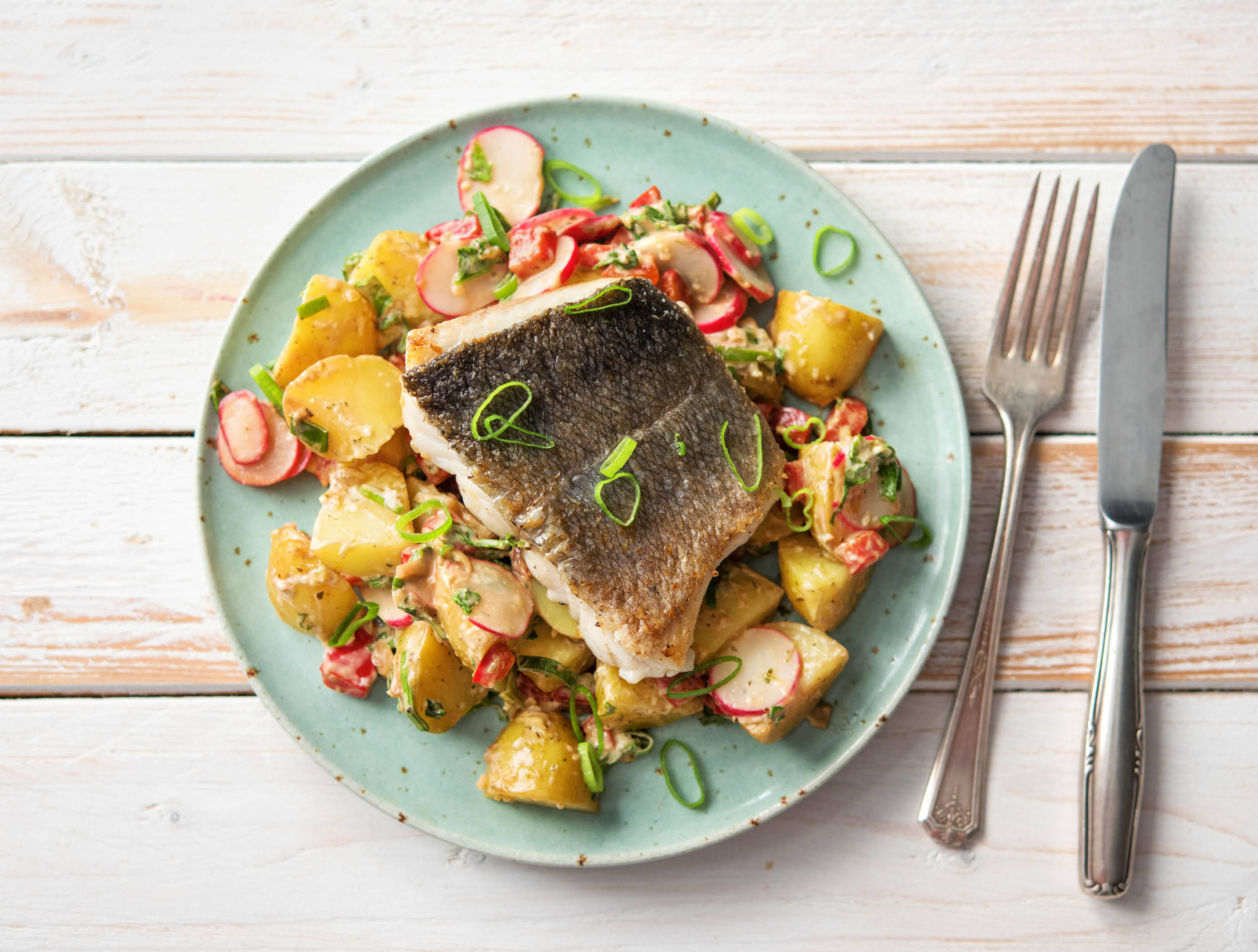 Op de huid gebakken heekfilet met kleurrijke aardappelsalade