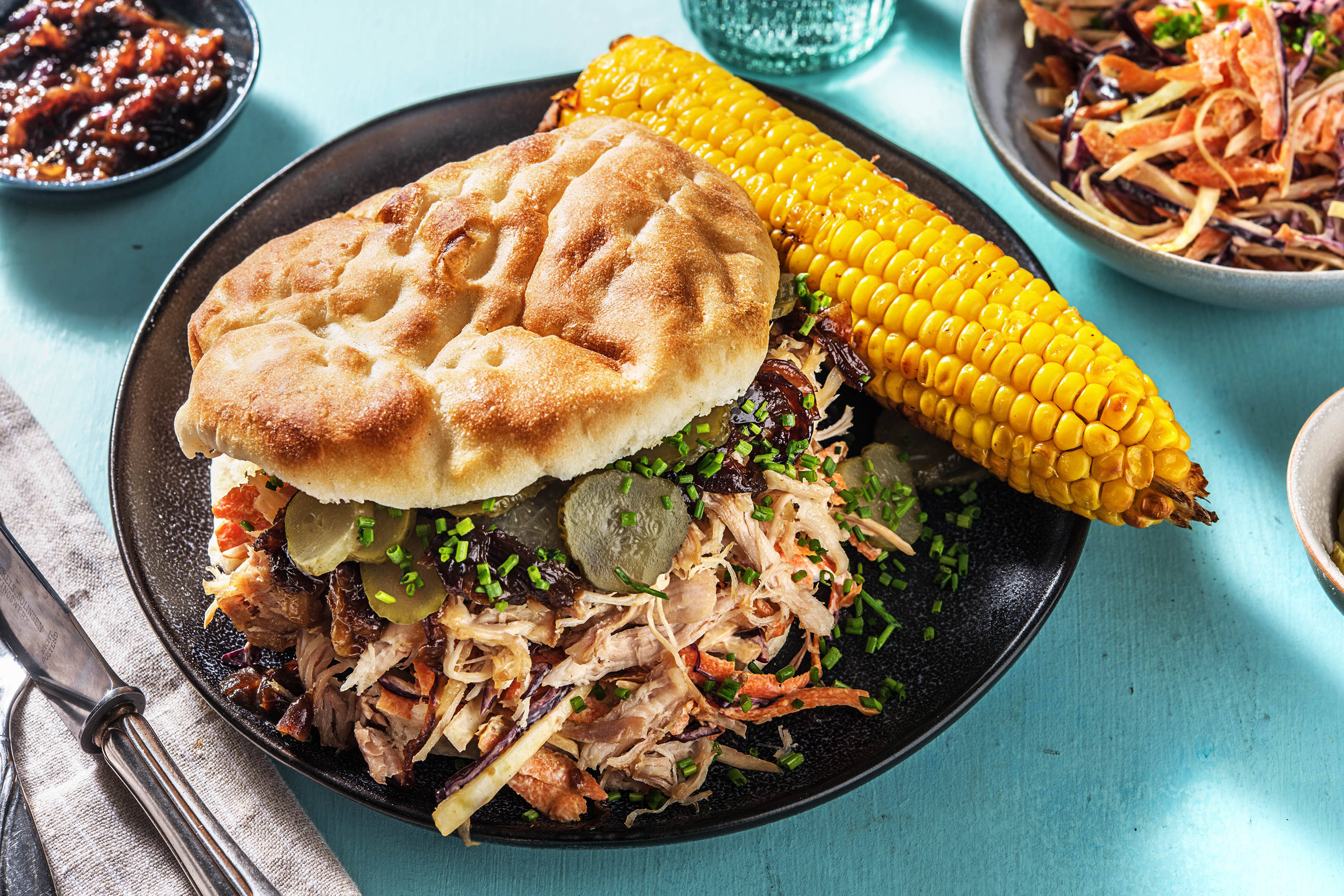 Effiloché de poulet avec coleslaw, épi de maïs et cornichons