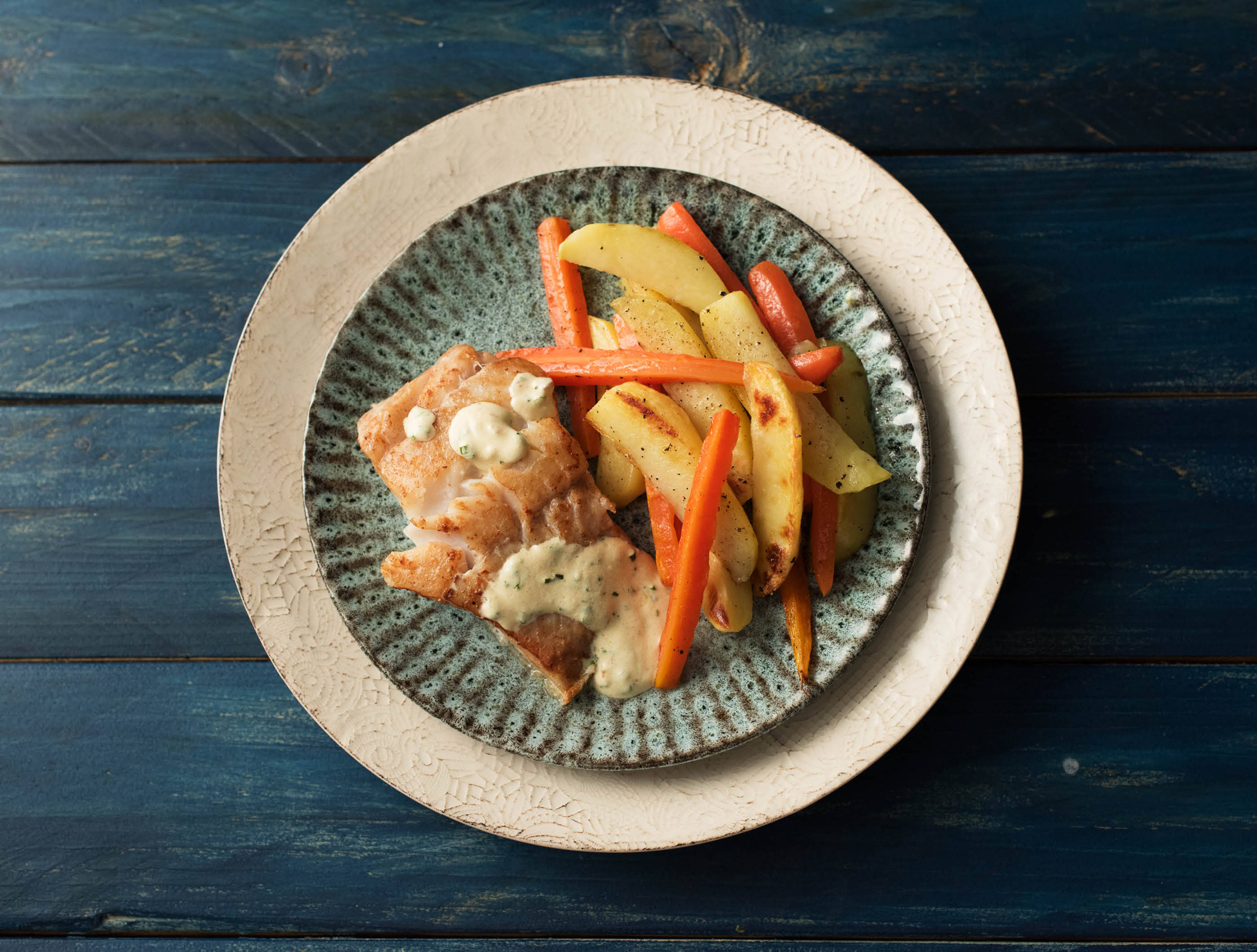 Schelvis met bieslooksaus en geroosterde bospeen en aardappelen
