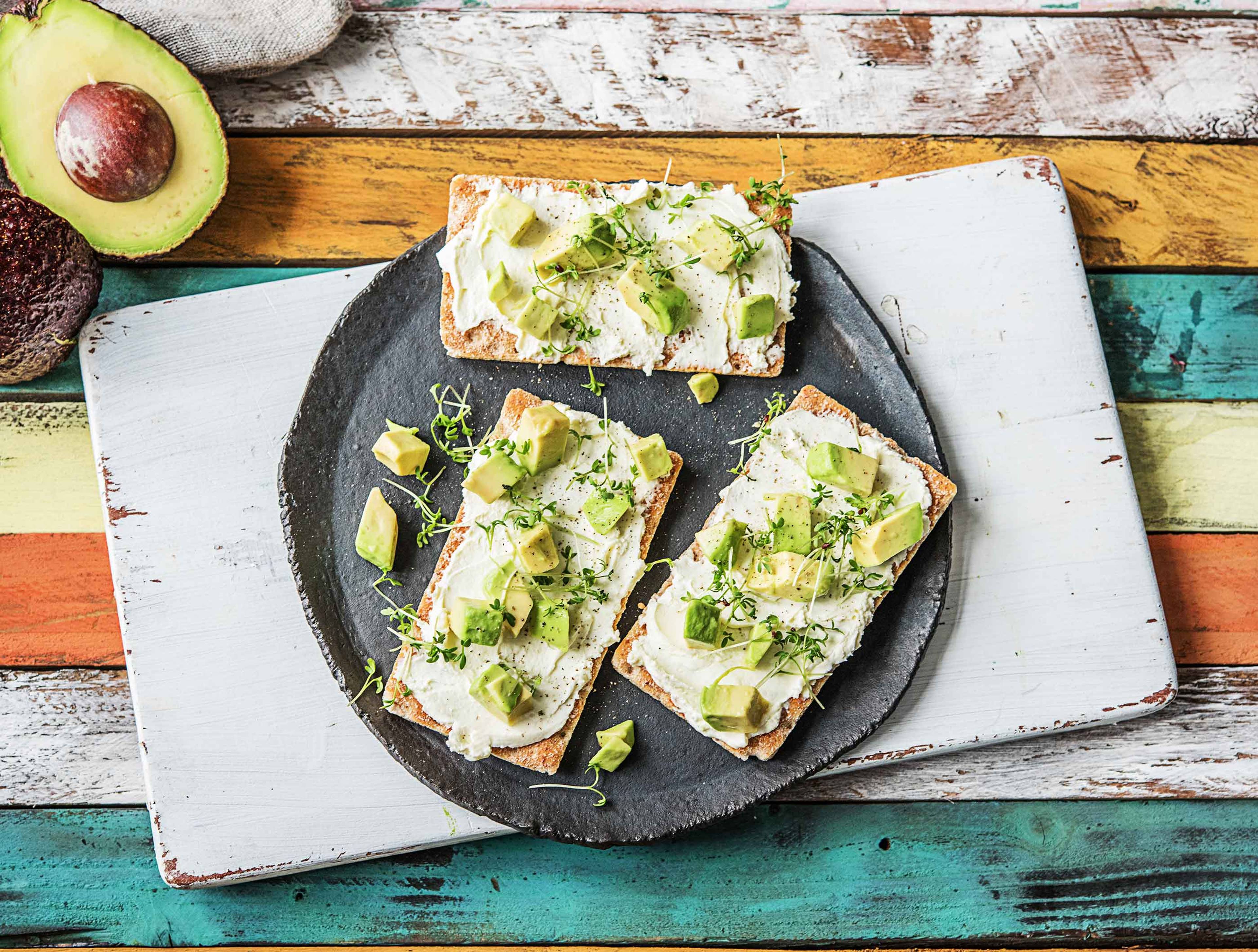 Vezelrijke crackers met verse geitenkaas, avocado en alfalfa