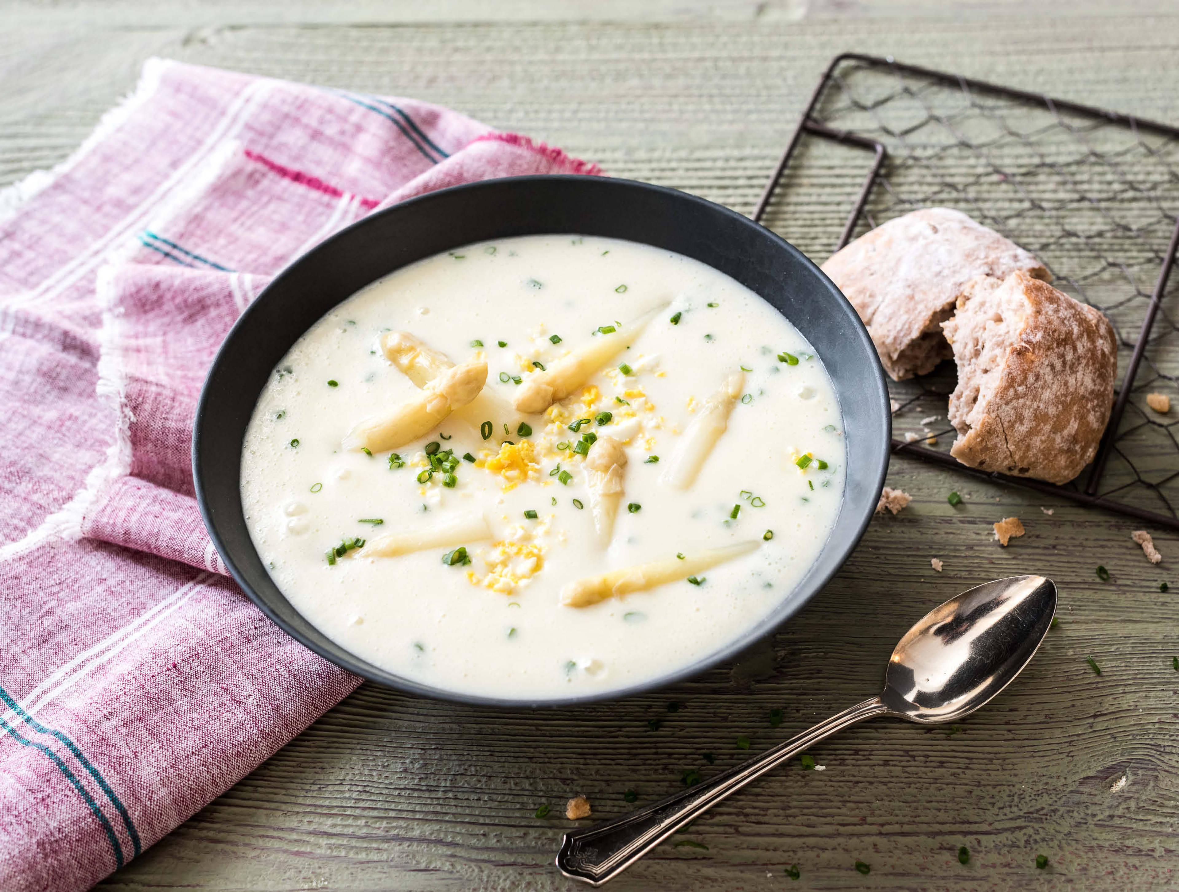 Witte aspergesoep met ei, bieslook en volkoren rozijnenbroodje