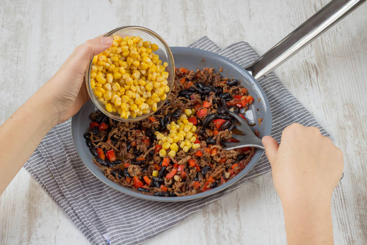 Toss the corn into the pan