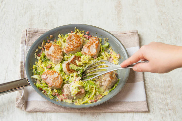 Das Schweinefilet zu der Wirsingpfanne geben.