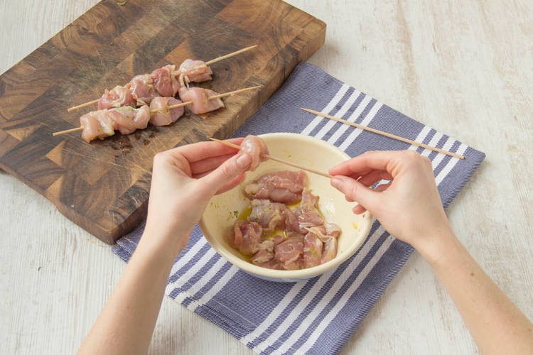 Das vorbereitete Hähnchenfleisch auf die Spieße stecken