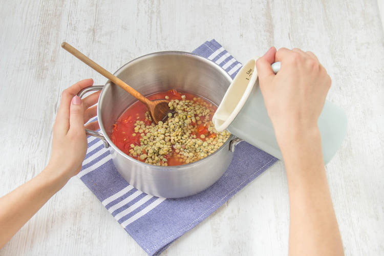Meng de linzen met de tomatenblokjes en water