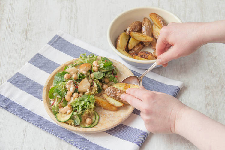 Verdeel de salade en gebakken krieltjes over de borden