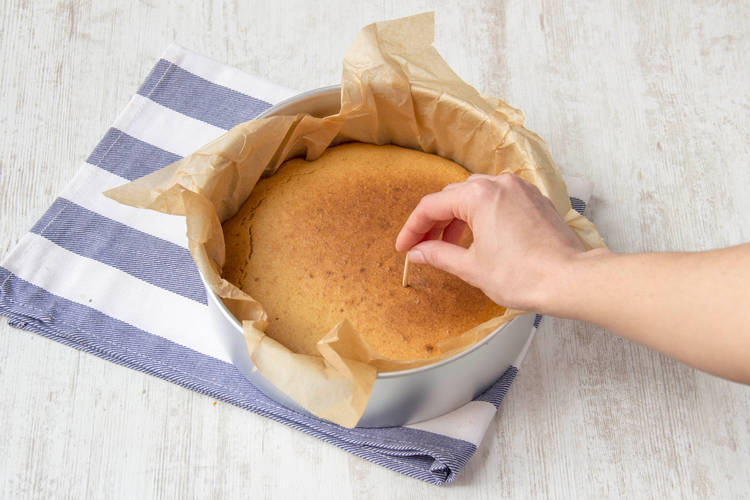 Prik met een satéprikker in de cake om te zien of deze gaar is