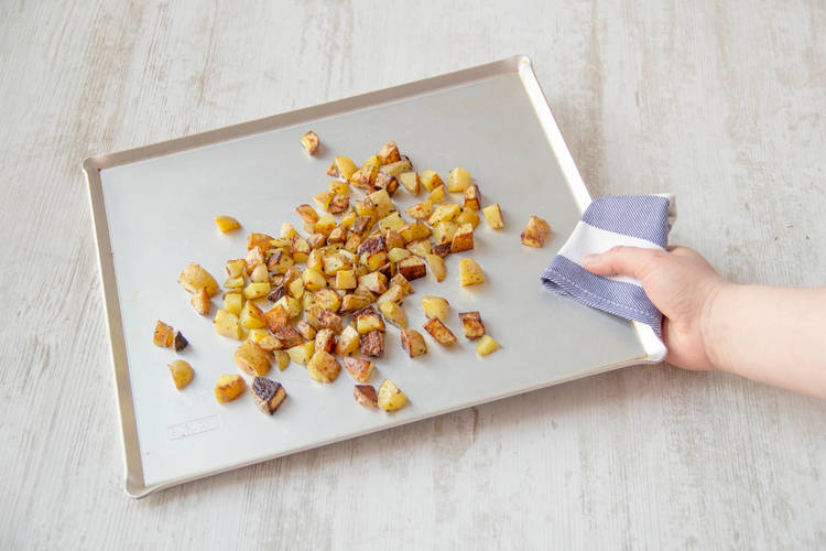 Cut, season, and toss the potatoes on a baking sheet