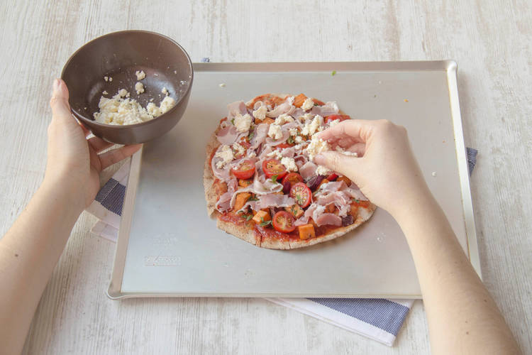 Scatter fetta cheese over pizza