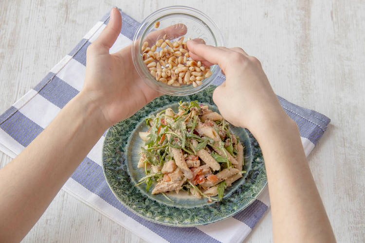 Garneer de salade met geroosterde pijnboompitten