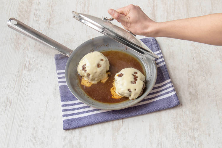 Cover the burgers with a lid to melt the cheese