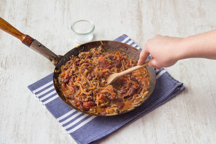 Stir beans, minced beef, and tomatoes into the pan