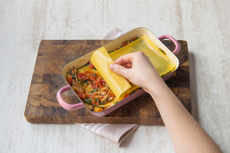 Bedek een laagje saus met groenten steeds met een laag lasagnebladen