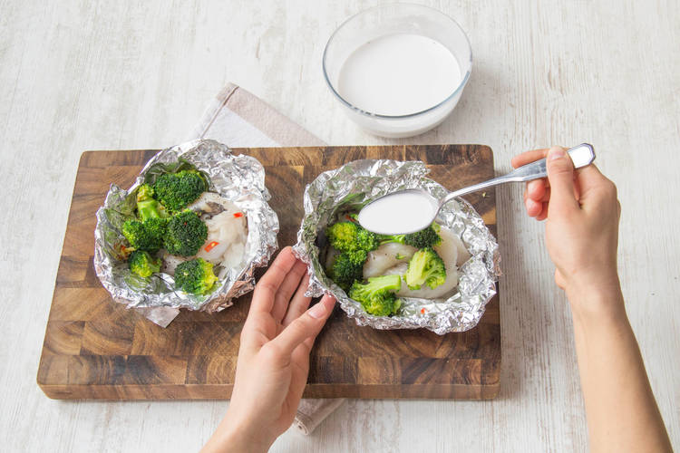 Verdeel de broccoli over de vis en besprenkel met kokosmelk