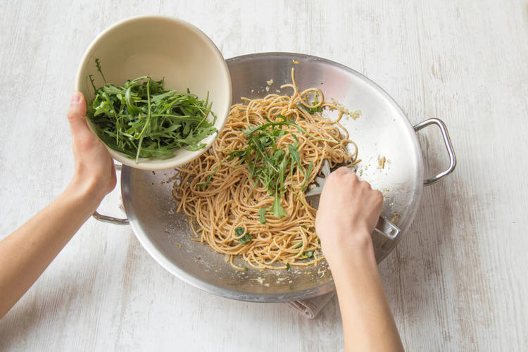 Voeg het grootste deel van de rucola toe aan de spaghetti