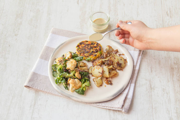 Serveer de aardappelen en de burger met de salade