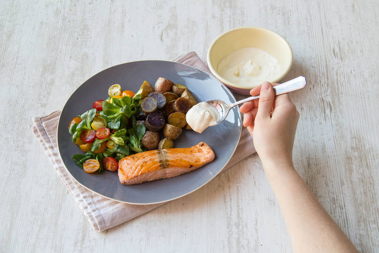 Verdeel de krieltjes, salade en zalmfilet over de borden