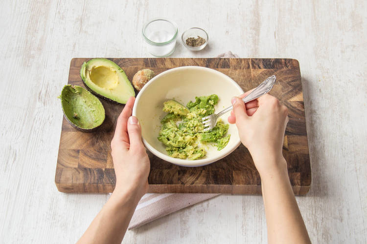 Das Avocado Fruchtfleisch mit einer Gabel zerdrücken