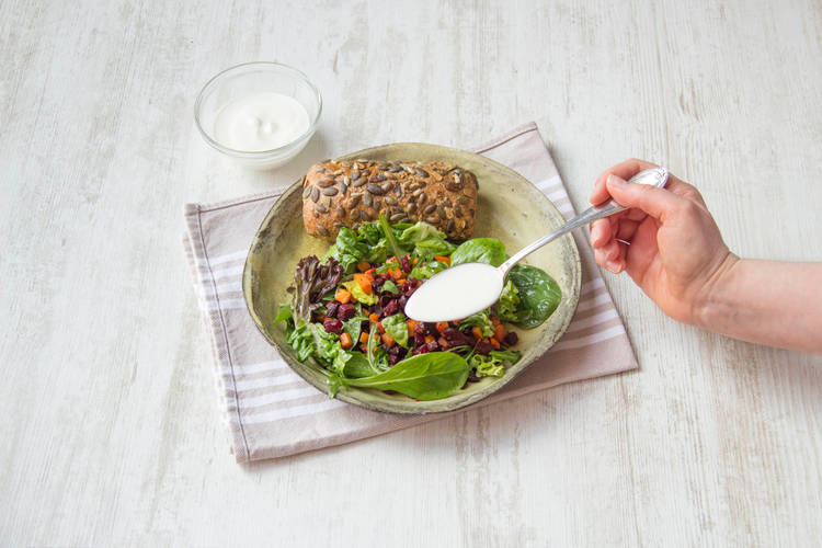 Verdeel de salade over de borden en schep de yoghurt over de salade