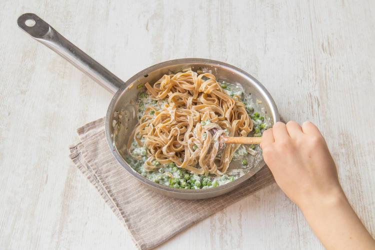 Fettuccine mit Soße vermengen