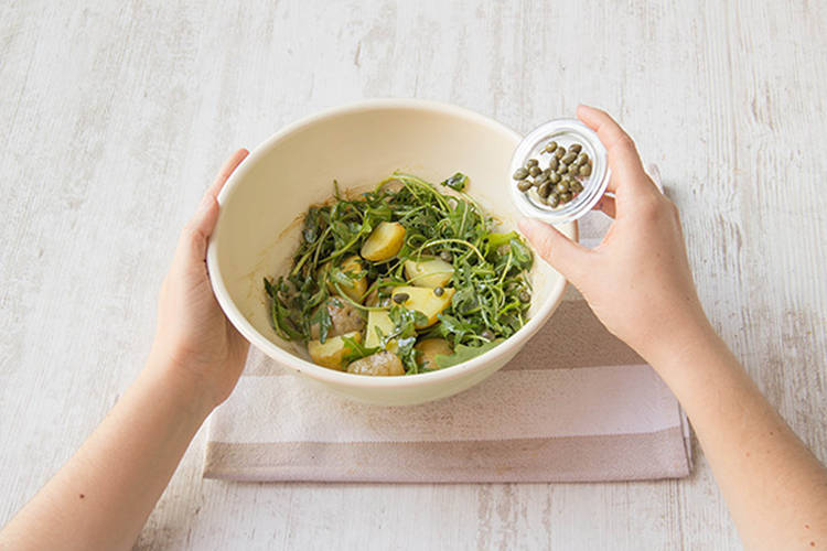 Toss potatoes and rocket with vinaigrette
