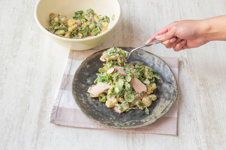 Verdeel de aardappelsalade over de borden