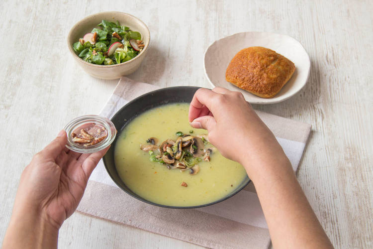 Serveer de soep met het spinazie-kaas-broodje en de salade