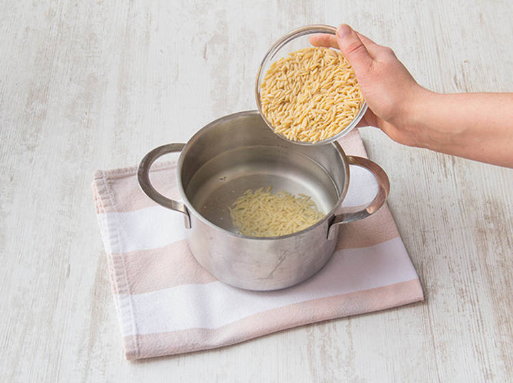 Orzo ins kochende Wasser geben