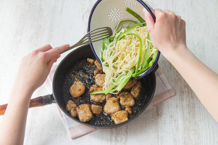Add the drained noodles and asparagus to the pork
