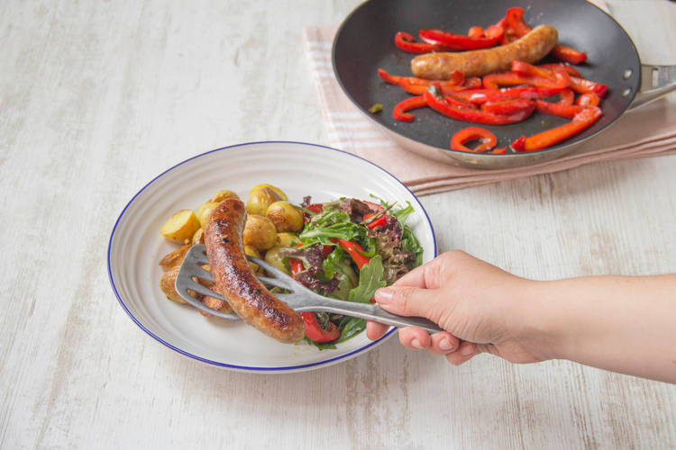 Verdeel de worst en krieltjes over de borden en serveer met de salade.