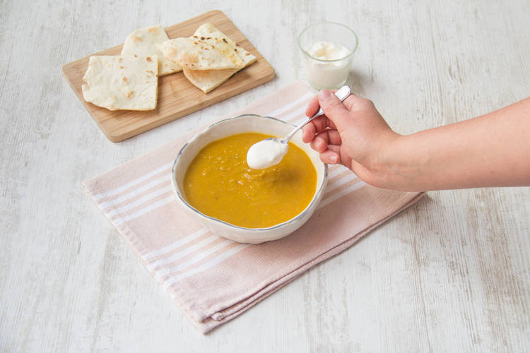Garneer de soep met creme fraîche