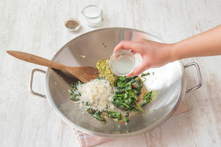 Voeg de groene pesto en kaas toe