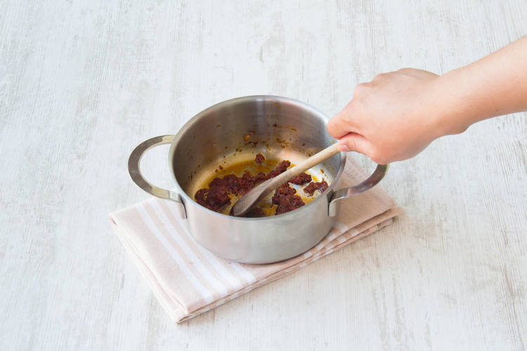 Bak de tomatenpuree met de oregano en knoflook