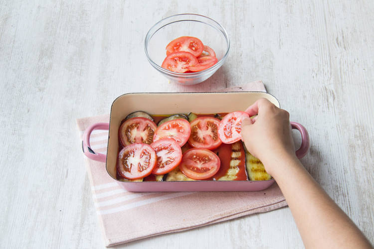 Verdeel de tomaat over de aubergine
