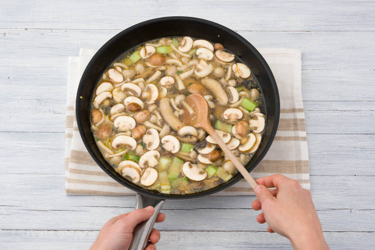 Voeg de paddenstoelen en de bouillon toe
