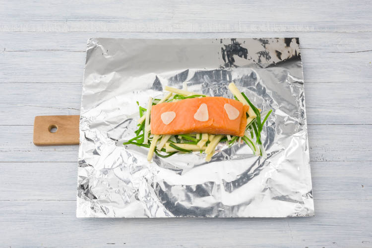 Leg bovenop de zalm de knoflook
