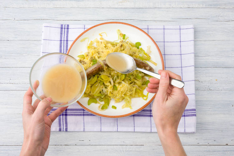 Besprenkel met bakvet en verdeel het gerecht over de borden.