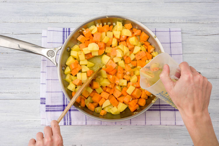 Voeg de aardappelen, bataat, winterpeen en het gekookte water toe.