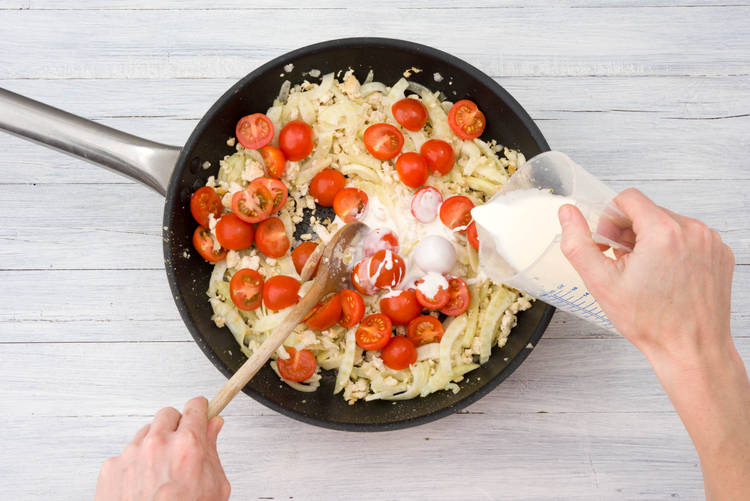 Voeg de kookroom en de cherrytomaten toe en roer goed door